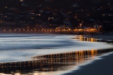 The reflection of the lights on St Clair Beach, Dunedin, New Zealand at dusk. 