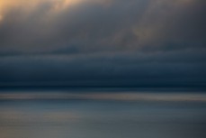 Storm clouds on the horizon at dawn over St Clair Beach, Dunedin, New Zealand. 