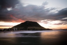 Troubled skies over Mauao (Mount Maunganui) as the sun sets, Bay of Plenty, New Zealand. 