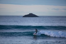 Justin rides a wave to the beach at dawn, St Clair Beach, Dunedin, New Zealand. 